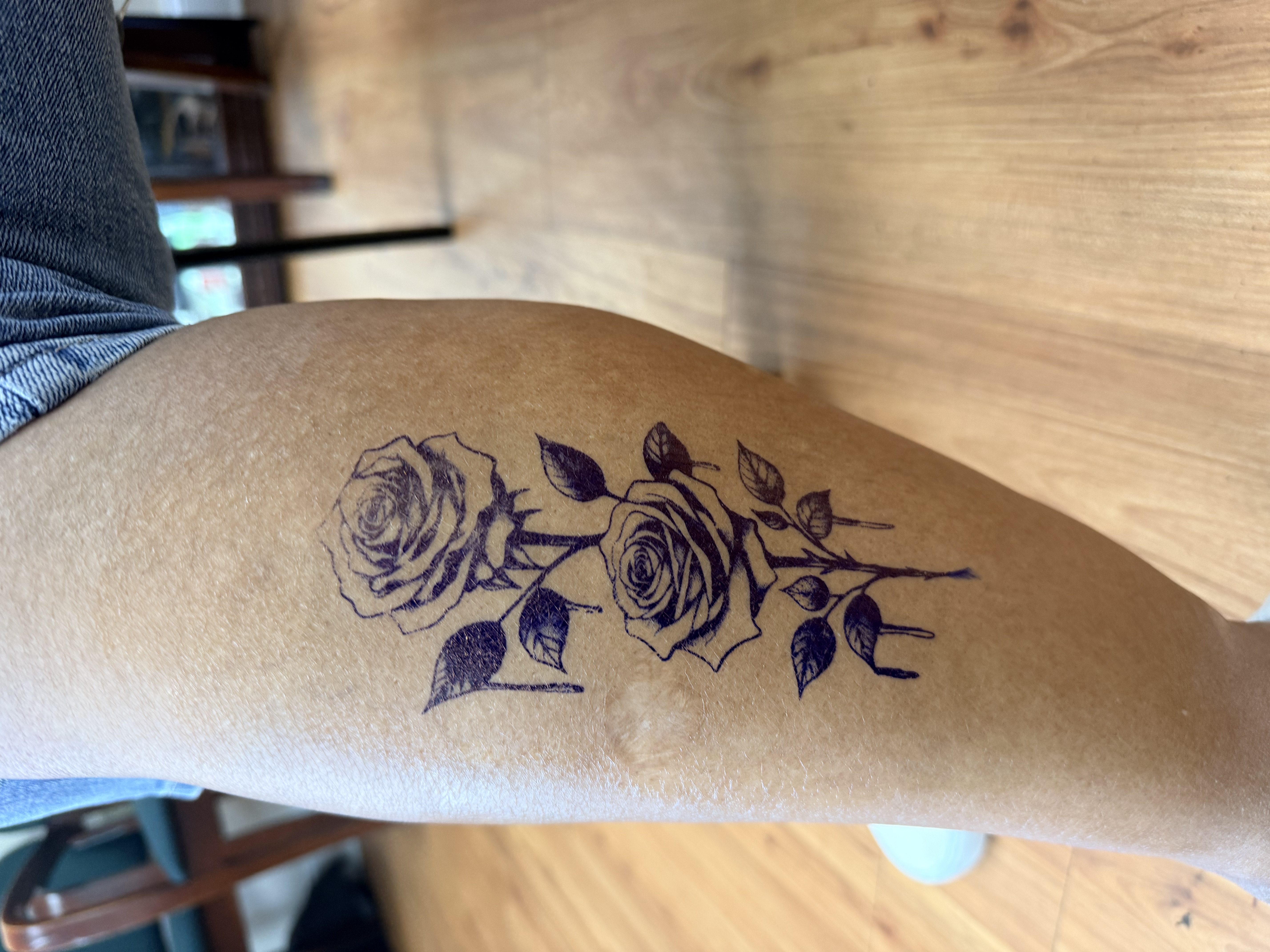 Black and grey fine line double rose tattoo — fresh on the thigh